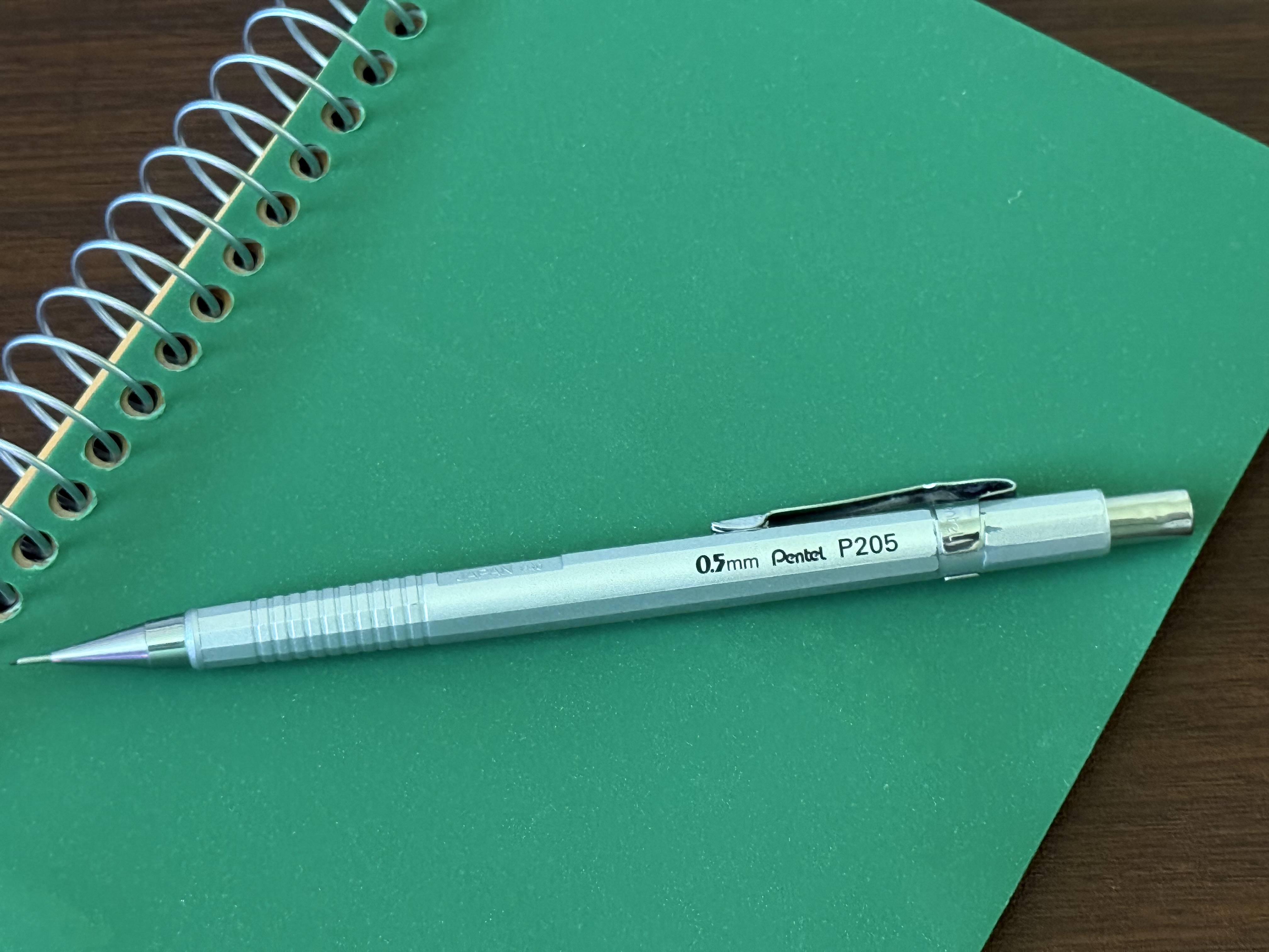 Mechanical pencil resting on a dark textured surface